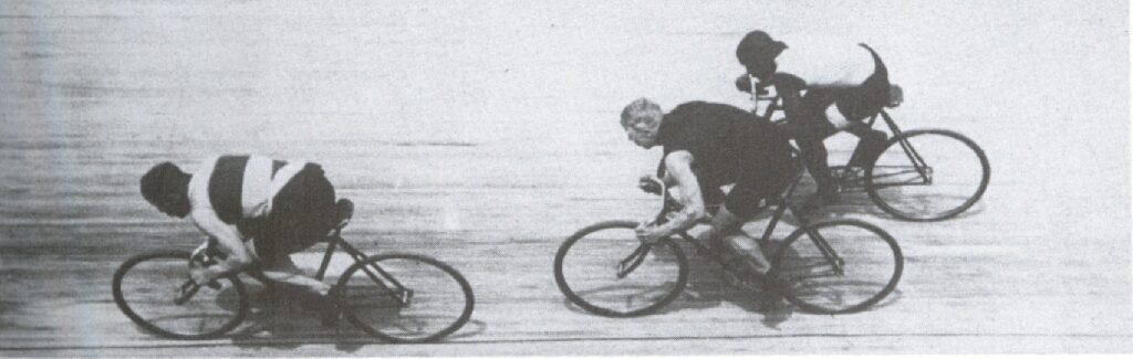 A rare action shot in Paris, 1903. Taylor comes from behind (on the outside) to contest a sprint with Harry Meyers of Holland and Thorwald Ellegaard of Denmark. The difference between Taylor's extended "modern" position and the contracted positions of the other two champions is clearly visible here. Jules Beau collection, Bibliotheque Nationale, Paris. This is the image used for one side of the Major Taylor monument in Worcester. | Courtesy Major Taylor Association, Inc.