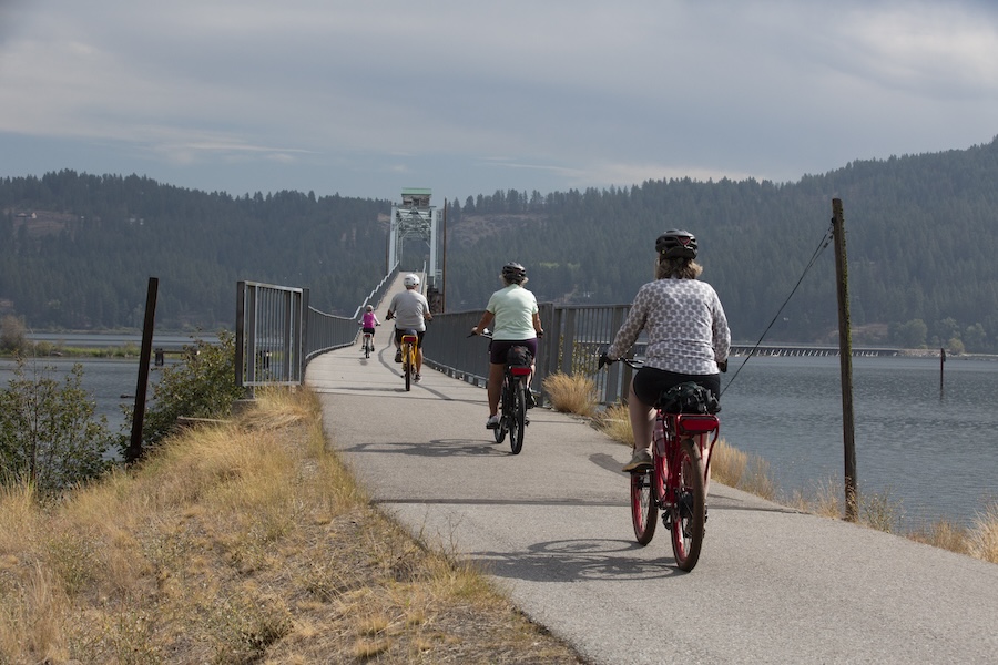Bicyclists approaching the Chatcolet Bridge on Idaho's Trail of the Coeur d'Alenes | Photo by Glenn Zinkus