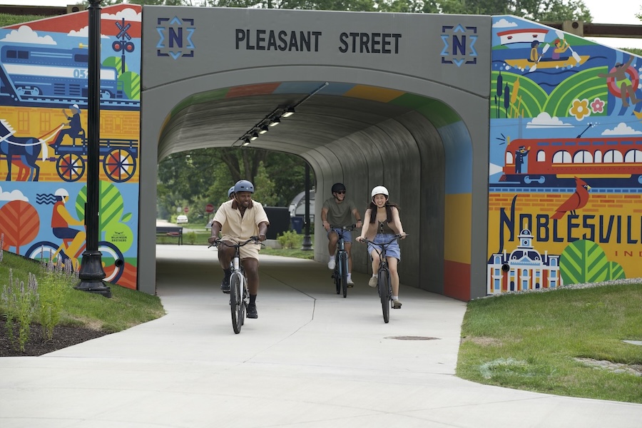 Bicyclists ride through tunnel with mural along Indiana's Nickel Plate Trail along Pleasant Street in Noblesville | Photo courtesy Hamilton County Tourism