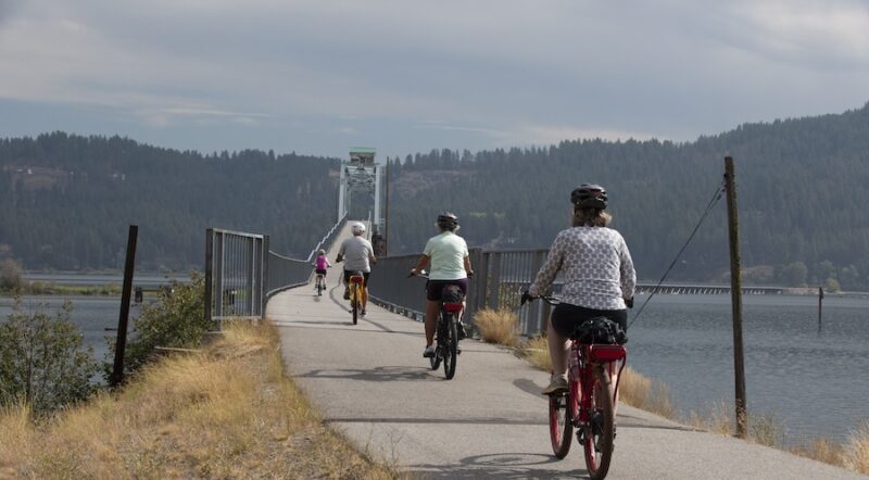 Bicyclists approaching the Chatcolet Bridge on Idaho's Trail of the Coeur d'Alenes | Photo by Glenn Zinkus