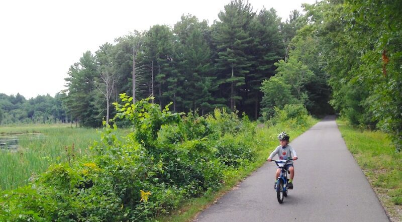 Child riding bicycle on New Hampshire's Derry Rail Trail | Photo by Ben Carter
