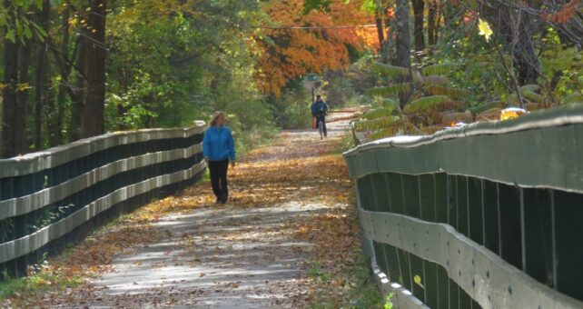Walker and bicyclist on New Hampshire's Derry Rail Trail | Photo Courtesy Derry Rail Trail Alliance