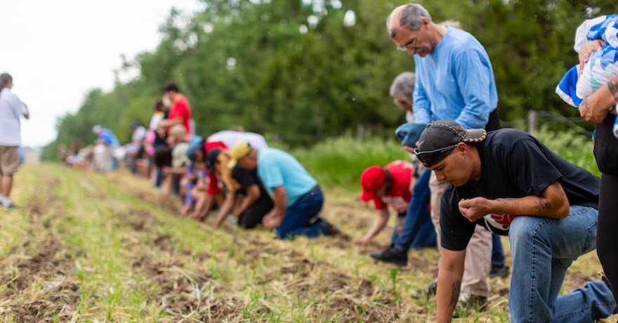 Volunteers participate in a sacred corn planting in 2019, sowing the seeds by hand. | Photo by Alex Matzke, courtesy Bold Nebraska
