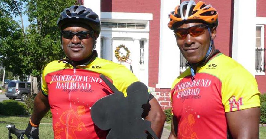 Mario Brown from the Center for Health Equity at the University of Pittsburgh and Adventure Cycling member George Thomas in front of Bertie Hall, along the Niagara River Recreation Trail in Ontario, Canada, during the 2007 inaugural tour of the Underground Railroad Bicycling Route | Photo by C. Spratling, courtesy Adventure Cycling Association