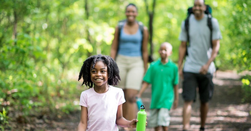 Black family walking in woods - Photo courtesy iStock by Getty Images