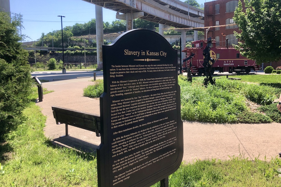 A commemorative sign at the Freedom Mall in Kansas City along the riverfront trail explains the role that the Missouri/Kansas border played in the fight to abolish slavery. “The border between Missouri and Kansas was once the most contested dividing line in the nation,” it says, adding that “[t]o many slaves in this area, the border meant one thing: freedom.” | Photo by Cindy Barks