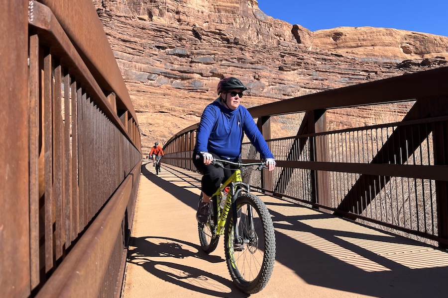 A bike rider crosses the pedestrian/bike bridge over the Colorado River at Lions Park. Photo by Cindy Barks