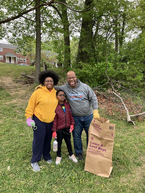 A family participating in cleanup at the Herring Run Trail as part of the 2024 Celebrate Trails Day celebration.