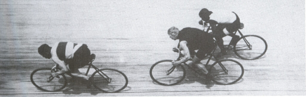 A rare action shot in Paris, 1903. Taylor comes from behind (on the outside) to contest a sprint with Harry Meyers of Holland and Thorwald Ellegaard of Denmark. The difference between Taylor's extended "modern" position and the contracted positions of the other two champions is clearly visible here. Jules Beau collection, Bibliotheque Nationale, Paris. This is the image used for one side of the Major Taylor monument in Worcester. | Courtesy Major Taylor Association, Inc.
