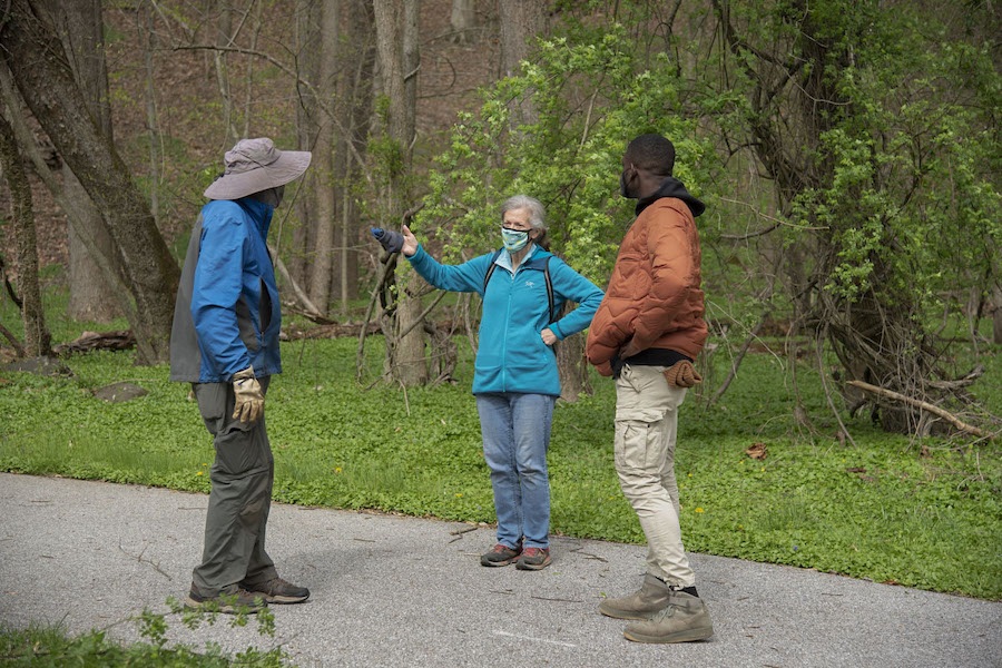 Bridget McCusker speaks with a volunteer and Ethan Abbott on the Gwynns Falls Trail | Photo by Arielle Bader
