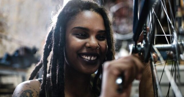 Female young technician looking at the camera in her bicycle repair shop | Photo courtesy RTC