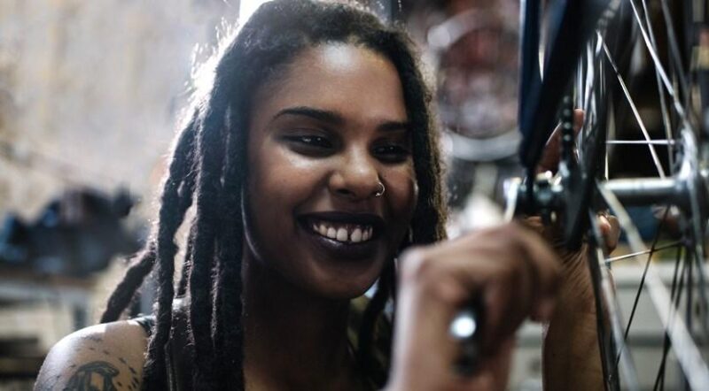 Female young technician looking at the camera in her bicycle repair shop | Photo courtesy RTC