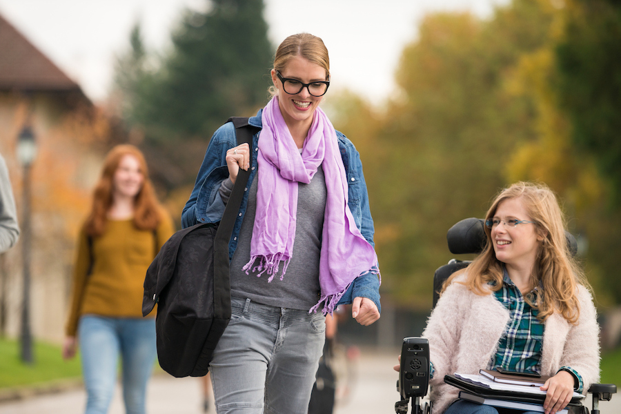 Student Walking Beside A Friend With Disability