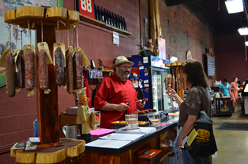 Hermann Wurst Haus owner Mike Sloan shares his award-winning sausages with a customer. The popular establishment sits 2 miles from the Katy Trail. | Photo by Danielle Taylor