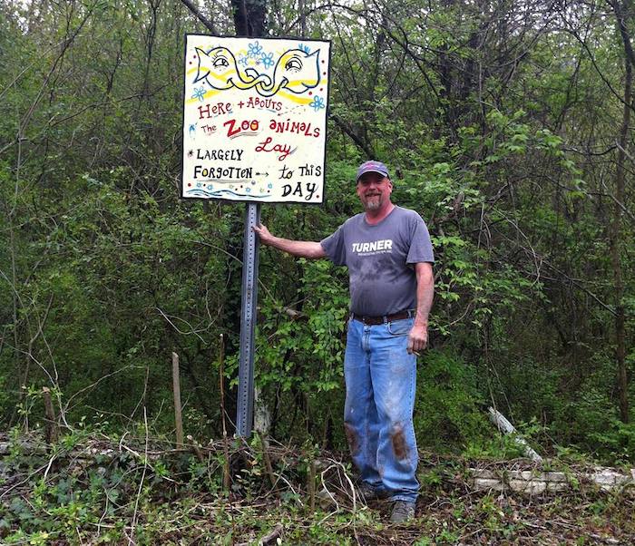 Joel Slaton, creator of the Dolls Head Trail, with a sign by artist Kyle Brooks (BlackCatTips.com) | Photo by Kyle Brooks