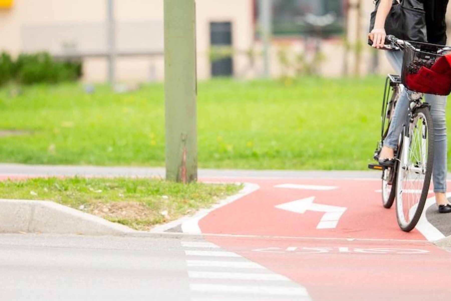 Young Woman on Bicycle Waiting at crosswalk - Photo courtesy Getty Images
