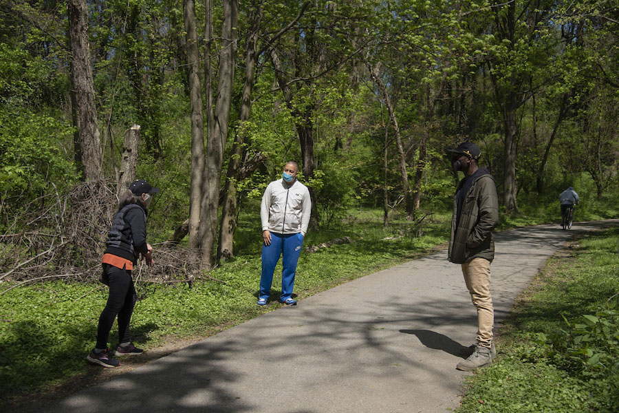 Scott Johnson and Ethan Abbott speak with a neighbor on the Herring Run Trail | Photo by Arielle Bader