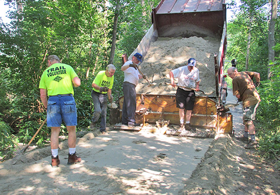 Volunteers installing a crushed limestone surface on the Montour Trail in South Park Township. | Photo courtesy Montour Trail Council