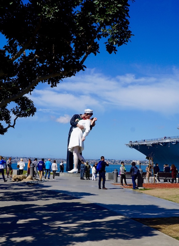 A ferry ride from Coronado to San Diego takes riders to the Broadway Pier, near the start of the Bayshore Bikeway. Also nearby: a California version of the “Unconditional Surrender” sculpture depicting a famous photograph taken in New York City’s Times Square on V-J Day in 1945. The statue is located next to the USS Midway Museum. | Photo by Cindy Barks