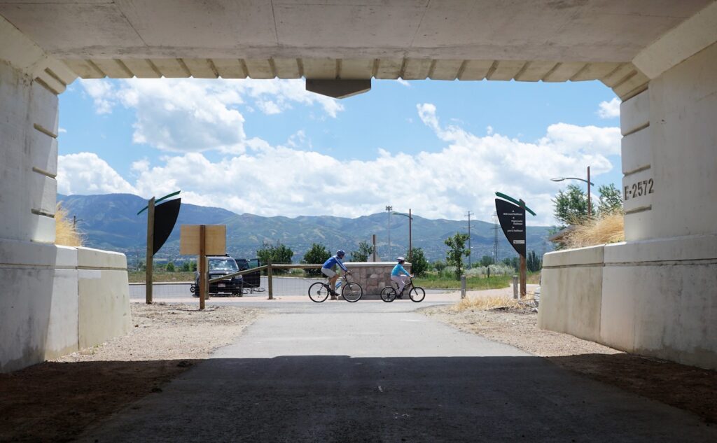 Cyclists pass by an underpass along the Legacy Parkway Trail that provides access to the Bountiful Pond. | Photo by Cindy Barks