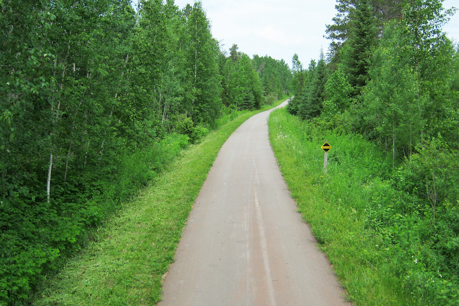 Nestled in woodlands, the Paul Bunyan State Trail skirts numerous lakes on its 119-mile journey. One of the longest rail-trails in the country, the pathway connects more than a dozen communities in north-central Minnesota. Photo courtesy Minnesota Department of Natural Resources.