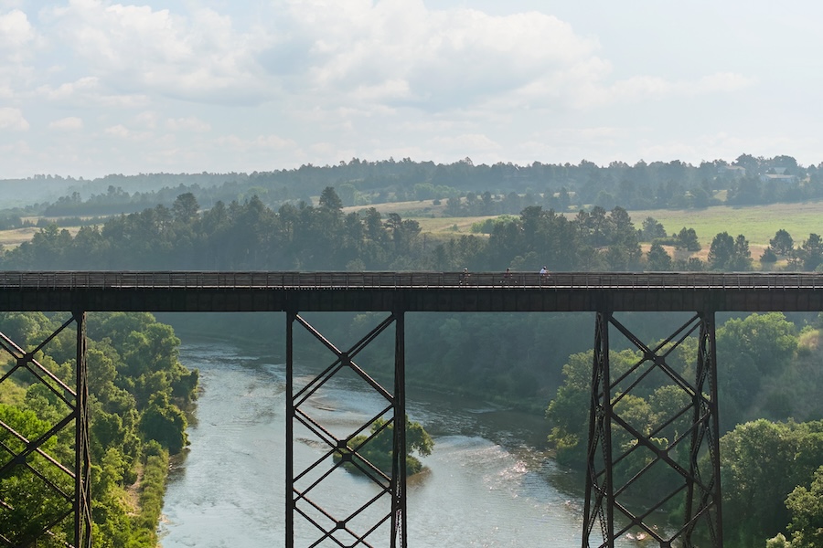 View of lake and forest through the legs of the Cowboy Trail Bridge