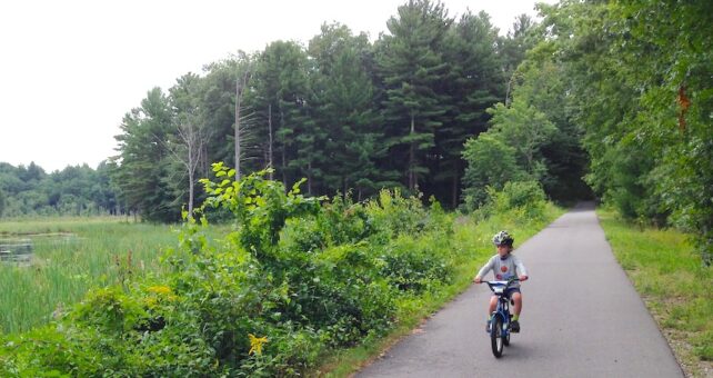 Child riding bicycle on New Hampshire's Derry Rail Trail | Photo by Ben Carter