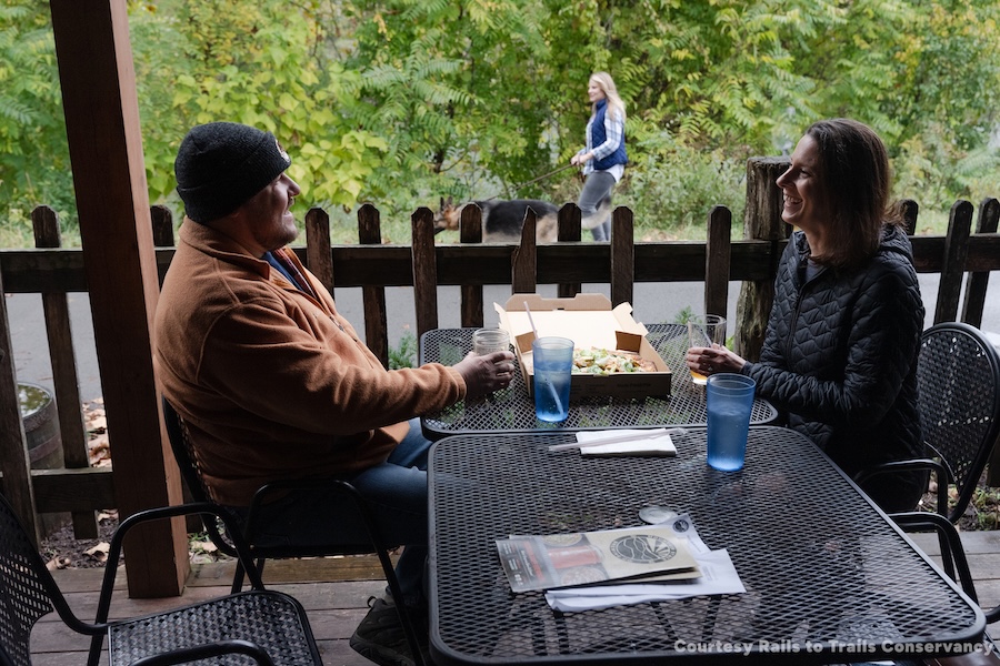 Active Transportation - dogwalker and people eating at trailside restaurant along West Virginia's Caperton Rail Trail | Photo by Renee Rosensteel