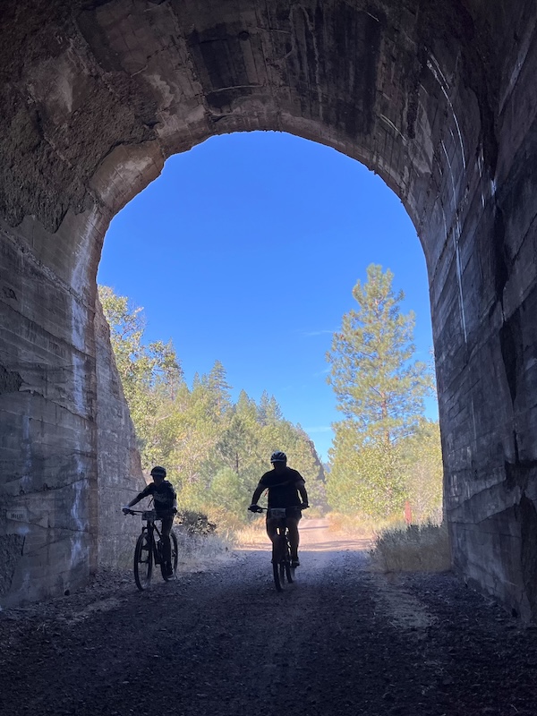 Bicyclists ride through a tunnel on California's Bizz Johnson Trail | Photo by Cindy Barks